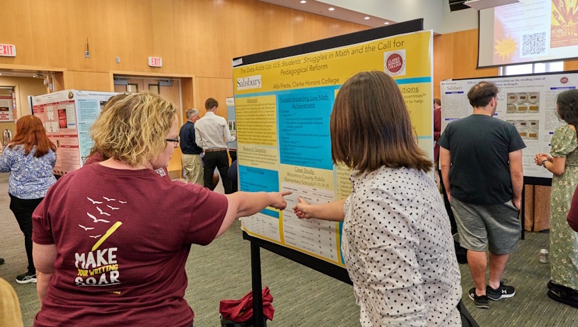 Students presenting posters in a large hall